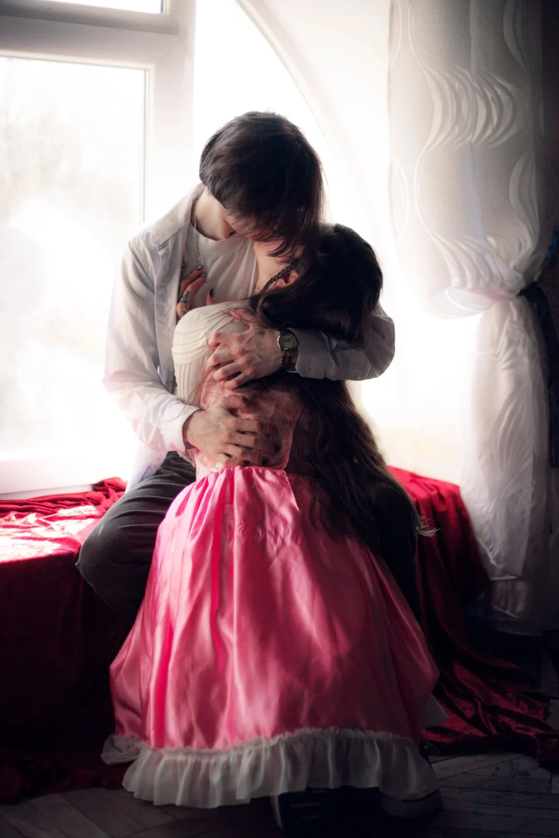 Two adults sharing a quiet intimate moment by a window
