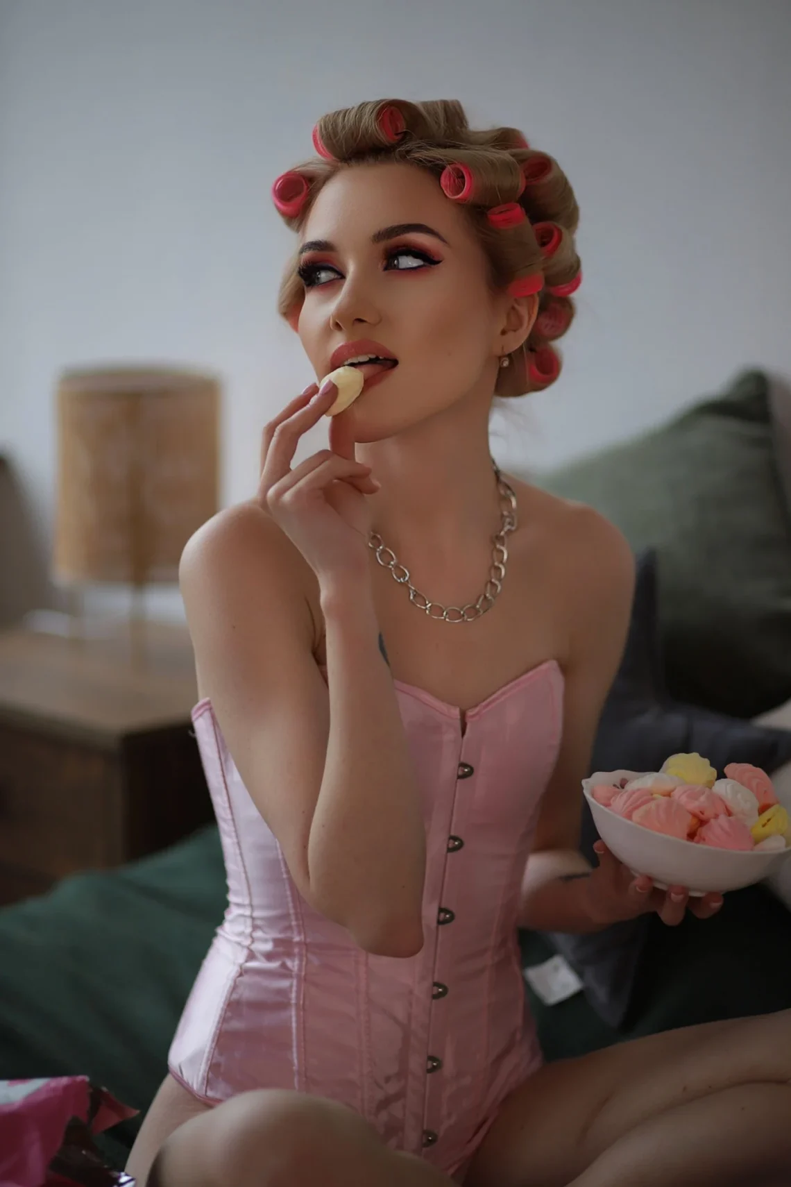 Feminine adult posing in a white corset indoors