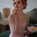 Feminine adult posing in a white corset indoors